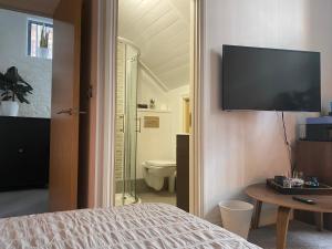 1 dormitorio con 1 cama y TV en la pared en WE-stay en Mánchester