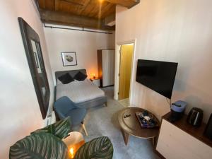 1 dormitorio con 1 cama, TV y sofá en WE-stay en Mánchester