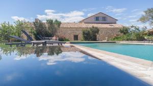 una piscina con mesa de picnic y una casa en Domaine de la Calamande, en Grillon