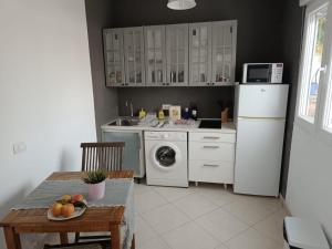 cocina con nevera blanca y lavadora en One bedroom apartement with sea view and wifi at Las Palmas, en Corralejo