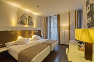 Habitación de hotel con cama grande y escritorio. en Gran Hotel España, en Oviedo