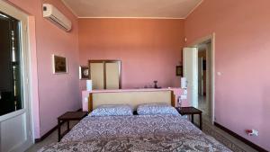 um quarto com uma cama e paredes cor-de-rosa em Villino Vanzetti 1930 em Cagliari