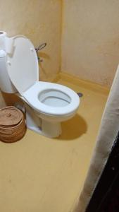 La salle de bains est pourvue de toilettes blanches. dans l'établissement Gite d'étape nomade, à Tajda