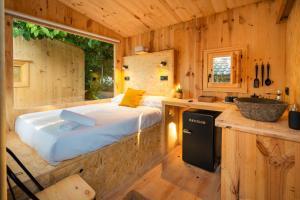 una camera da letto in una baita di tronchi con un letto e un lavandino di Kampaoh Isla Cristina a Isla Cristina