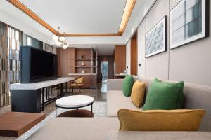 a living room with a couch and a tv at Hilton Garden Inn Beijing Daxing Jinyuan Road in Beijing