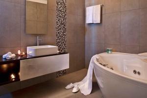 ein Badezimmer mit einer Badewanne und einem Waschbecken in der Unterkunft Beautiful Santorini Villa - 2 Bedroom Villa - Panoramic Caldera Sea Views and Private Plunge Pool - Megalochori in Megalochori
