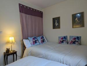 a bedroom with two beds and a table with a lamp at Sherlock's House--Moray House Comfy stay for 5 free private parking 1130Mbps broadband Idea for Twycross Zoo, Alton Towers, National Forest, National Cycle Route 63 in Church Gresley