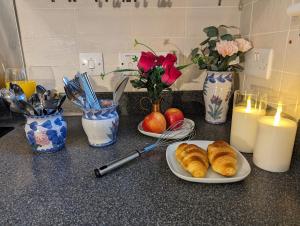 dos platos de croissants en un mostrador con velas y flores en Sherlock's House - Two bedroom terrace 3 beds 2 sofa beds Garden Private free parking & WIFI Accessibility Contractors Family & Kids & Pet are welcome en Church Gresley