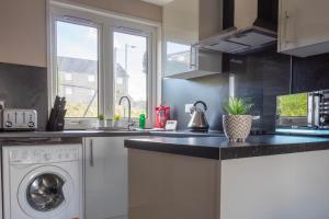 eine Küche mit einer Spüle und einer Waschmaschine in der Unterkunft Perth House in Clydebank