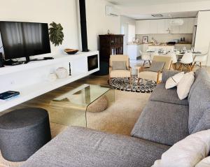 a living room with a couch and a tv at Villa Amêndoa in Loulé