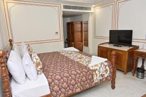 a bedroom with a bed and a flat screen tv at Hotel Rime Vista in Jaipur