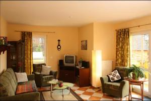 un salon avec un canapé et une télévision dans l'établissement Ferienwohnung Melosine, à Ostseebad Koserow