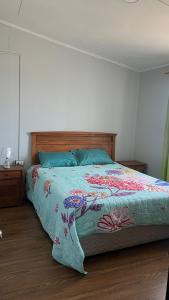 Un dormitorio con una cama con una manta de colores. en Ubicación central cabaña frente al mar, en Tocopilla