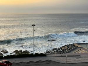 - une vue sur l'océan avec des vagues et une lumière de rue dans l'établissement Ubicación central cabaña frente al mar, à Tocopilla