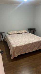 a bed in a room with two end tables at Ubicación central cabaña frente al mar in Tocopilla
