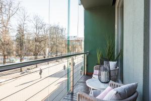 uma varanda com uma mesa e cadeiras num edifício em Belhome Küüni apartment in the city center em Tartu