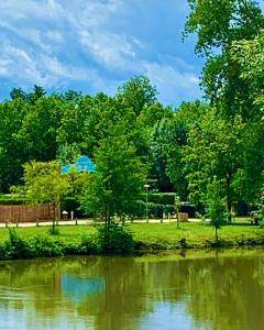 a park with trees and a body of water at Camping Paradis Aubeterre in Aubeterre-sur-Dronne