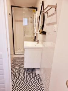 a white bathroom with a sink and a shower at in paris in Villejuif