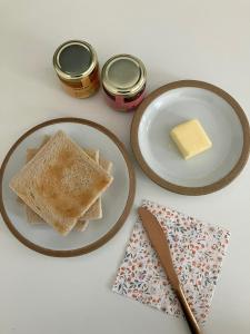 a table with two plates of toast and a piece of butter at in paris in Villejuif