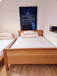 a bedroom with two beds and a painting on the wall at in paris in Villejuif