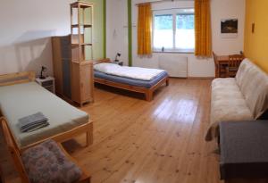 - un salon avec deux lits et un canapé dans l'établissement Ferienwohnung im Seidlerhof mit Balkon und Garten, à Röhrnbach