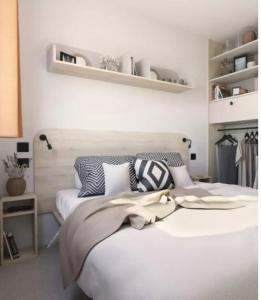 a bedroom with two beds with white walls at Camping Arcobaleno in Marina di Bibbona