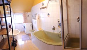a bathroom with a tub and a toilet and a sink at Ferienwohnung im Seidlerhof mit Balkon und Garten in Röhrnbach