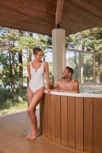 Um homem e uma mulher numa banheira de hidromassagem. em Hôtel Valdys Thalasso & Spa - les Pins em Saint-Jean-de-Monts