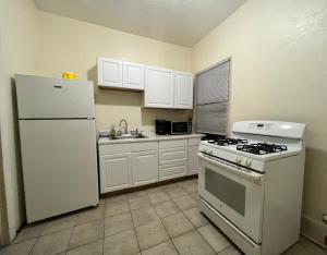 cocina con electrodomésticos blancos y nevera blanca en GUEST HOUSE NEAR DOWTOWN BOSTON, en Boston