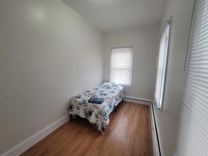 a small bedroom with a bed with a floral blanket at GUEST HOUSE NEAR DOWTOWN BOSTON in Boston