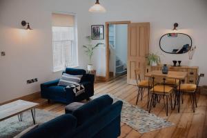 a living room with a blue couch and a table at Spacious Norwich Lanes Apartment with Roof Terrace in Norwich