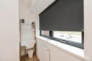 a room with a window with a black roller blind at Solihull Modern Living - 1 Bed Apartment in Solihull +13 photos