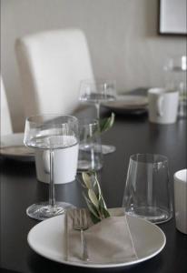 a table with glasses and a plate with a napkin at Modern, ruhig, gemütlich: 2 Zimmer Wohnung in bester Lage nahe Alster + Stadtpark in Hamburg