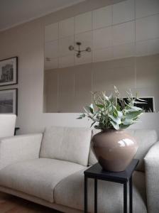 uma sala de estar com um sofá e um vaso sobre uma mesa em Modern, ruhig, gemütlich: 2 Zimmer Wohnung in bester Lage nahe Alster + Stadtpark em Hamburgo