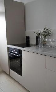 uma cozinha com um balcão e um forno preto em Modern, ruhig, gemütlich: 2 Zimmer Wohnung in bester Lage nahe Alster + Stadtpark em Hamburgo