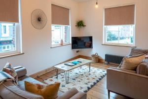 a living room with a couch and a table at Stylish Quayside Apartment with River View in Norwich