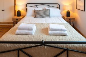 a bedroom with a bed with two pillows on it at Stylish Quayside Apartment with River View in Norwich