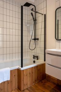 a bathroom with a shower and a bath tub at Stylish Quayside Apartment with River View in Norwich