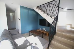 un soggiorno con divano e una scala di villa contemporaine 8 personnes a 150m de la plage a Sainte-Marie-Plage