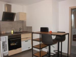 a kitchen with a table and two bar chairs at Grimm's Lodge in Lörrach