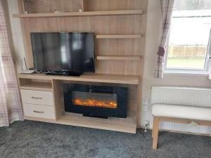 sala de estar con TV y chimenea en Bluebell corner - with small enclosed decking en Hastings