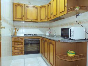 a kitchen with wooden cabinets and a microwave at Luque un pueblo con encanto in Luque