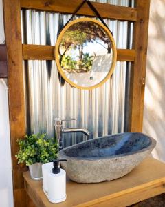 a bathroom with a large stone sink and a mirror at Kampaoh Isla Cristina in Isla Cristina