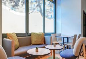 马赛B&B HOTEL Marseille Centre Vieux Port的一间设有桌子、沙发和窗户的等候室