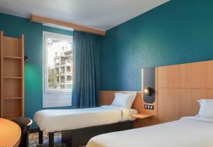马赛B&B HOTEL Marseille Centre Vieux Port的有两张床和一扇窗户的房间