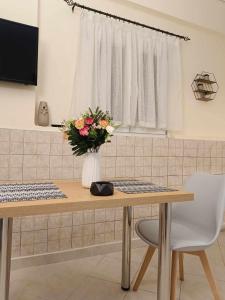a table with a vase of flowers on it at Lagadas Shiny apartments in Mytilini