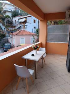 a balcony with a table and two chairs and a window at Lagadas Shiny apartments in Mytilini