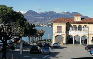 a street with cars parked in front of a building at Brezza di Lago in Stresa