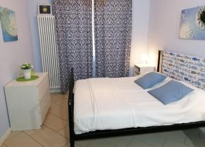 ストレーザにあるBrezza di Lagoのベッドルーム(白いベッド、青いカーテン付)