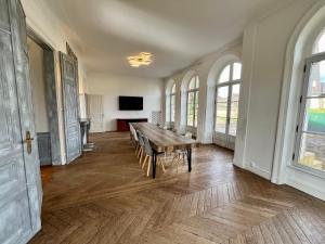 Cette grande chambre dispose d'une table et de chaises en bois. dans l'établissement Superbe Maison de maître 10 chambres 300 m2 Caen, à Bretteville-sur-Odon